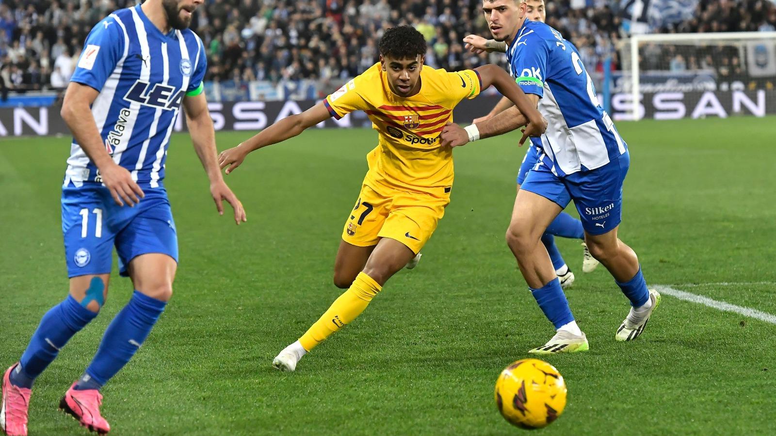 Barcelona's Lamine Yamal, centre, challenges for the ball with Alaves' Luis Rioja, left, and Alaves' Javi Lopez during the La Liga soccer match between Deportivo Alaves and FC Barcelona at the Medizorrosa stadium in Vitoria, Spain, Saturday, Feb. 3, 2024.