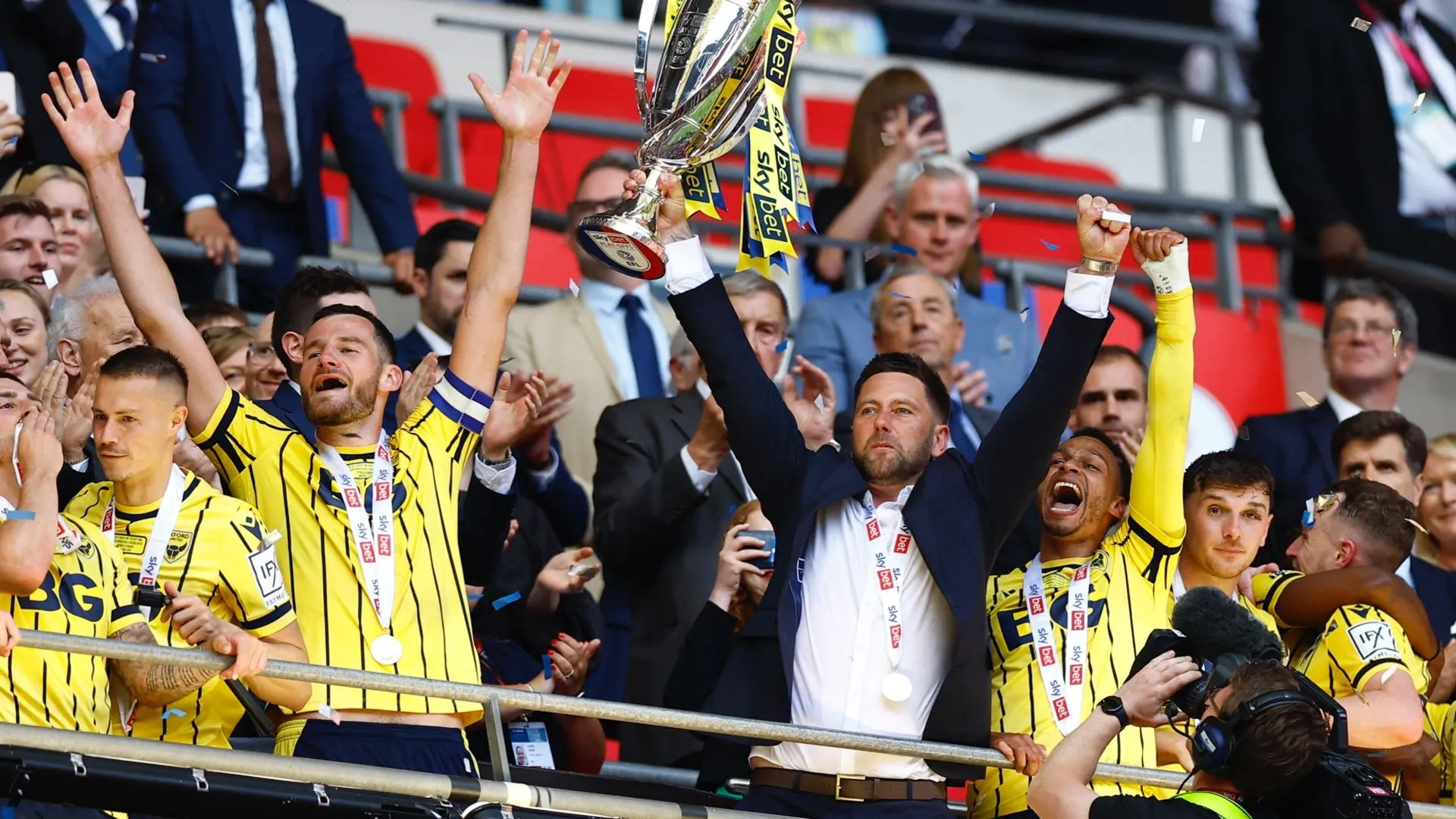 Des Buckingham ăn mừng cùng cầu thủ Oxford United sau khi thăng hạng Championship